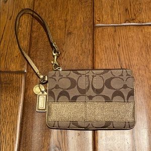 Brown and gold small Coach wristlet.